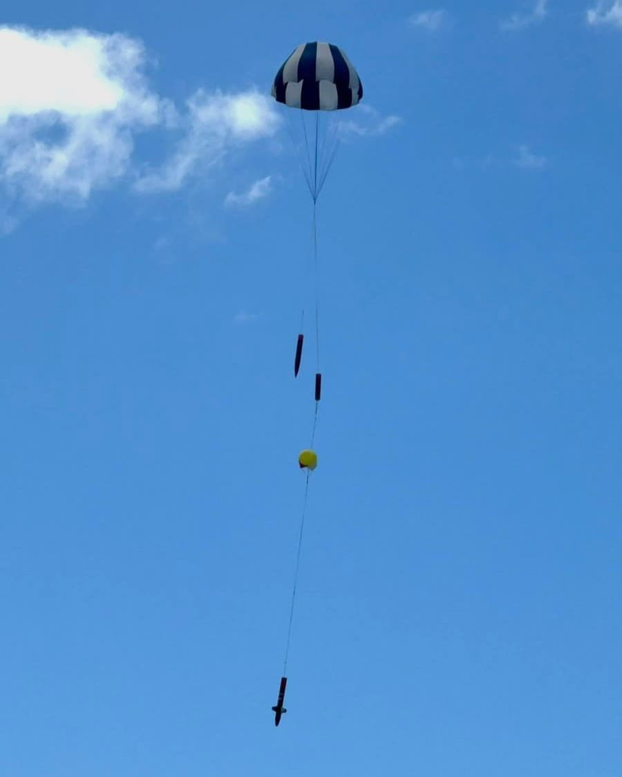 Rocket descending under deployed parachutes