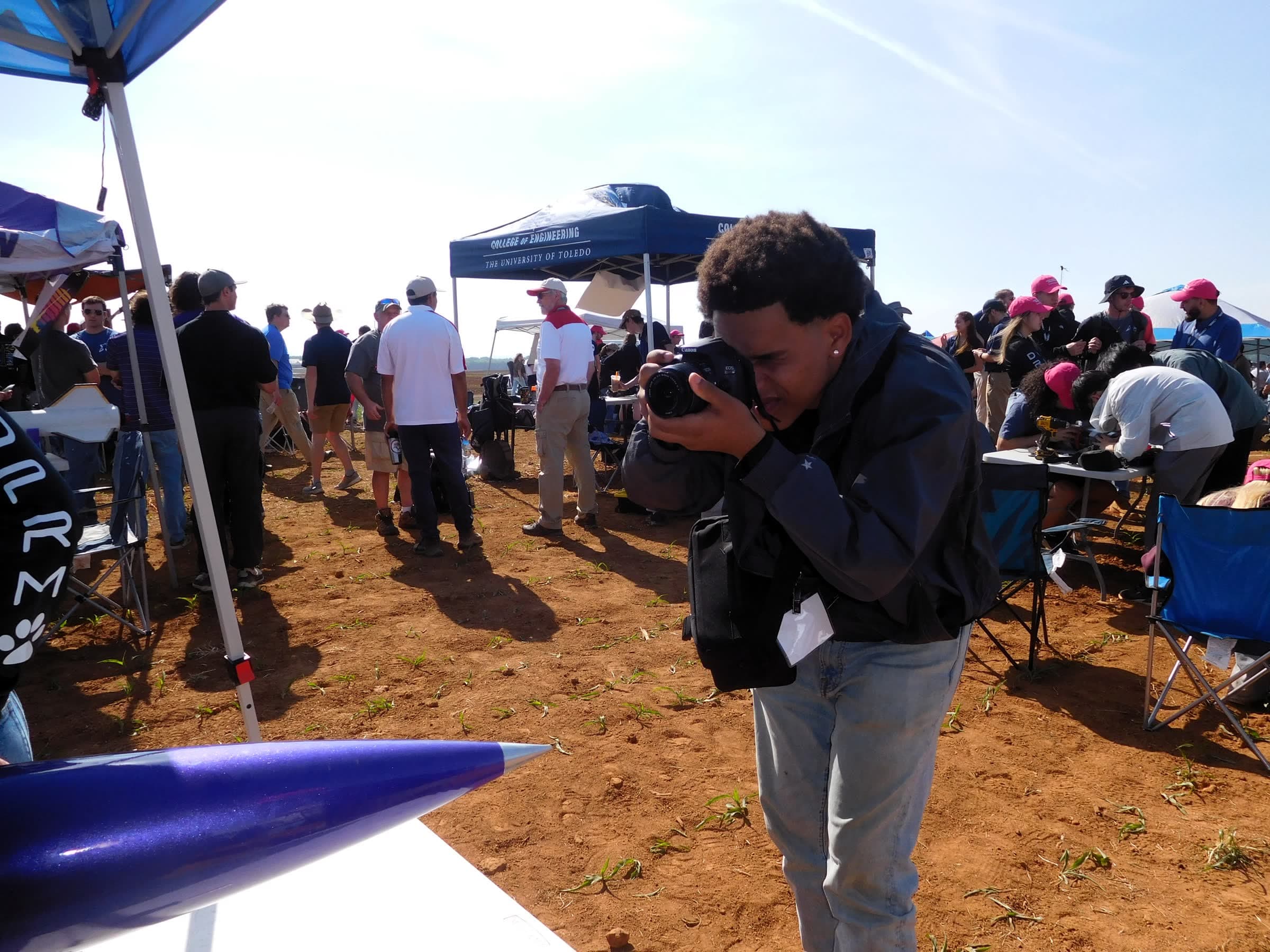 A DRACO member photographing the team's rocket with a DSLR at the competition field